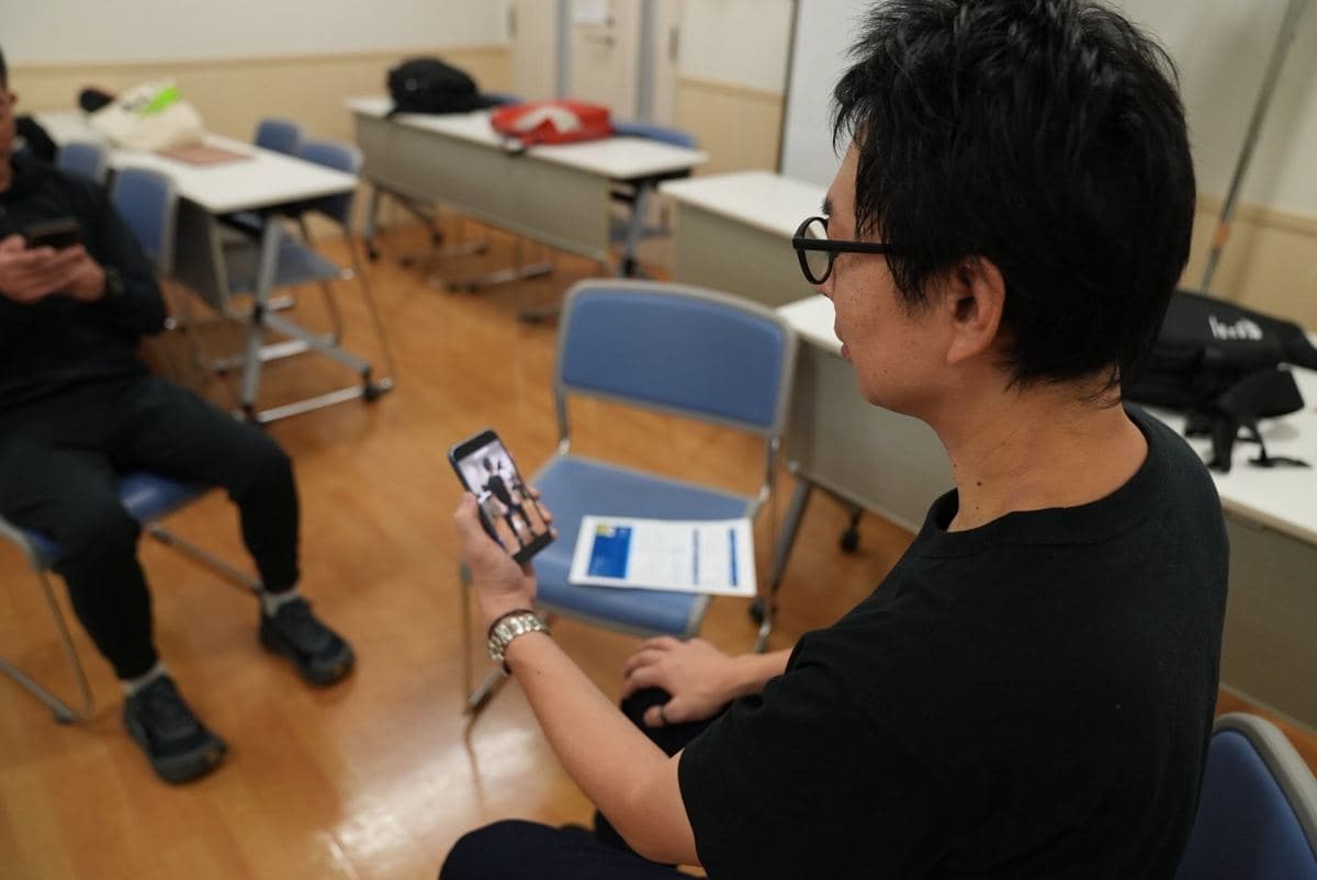 スマートフォンで自分の動きを見返す参加者